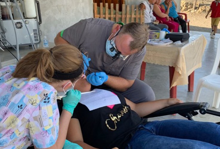 Doctor Owens treating dental patient at community event