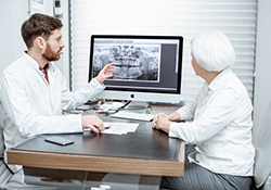 Implant dentist in Geneva explaining treatment to a patient