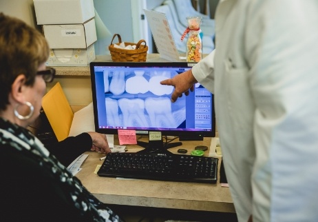 Dentist and team member looking at dental implant patient's x-rays