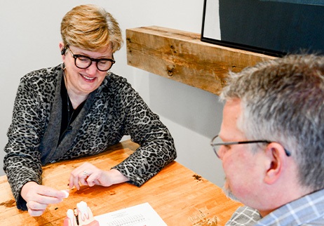 Dental team member and patient reviewing dental implant cost information