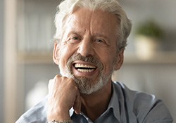 man smiling after getting dental implants in Geneva