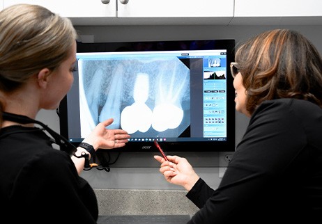Dentist and team member looking at dental implant patient's x-rays