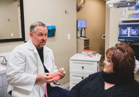 Dental team member and patient reviewing dental implant cost information