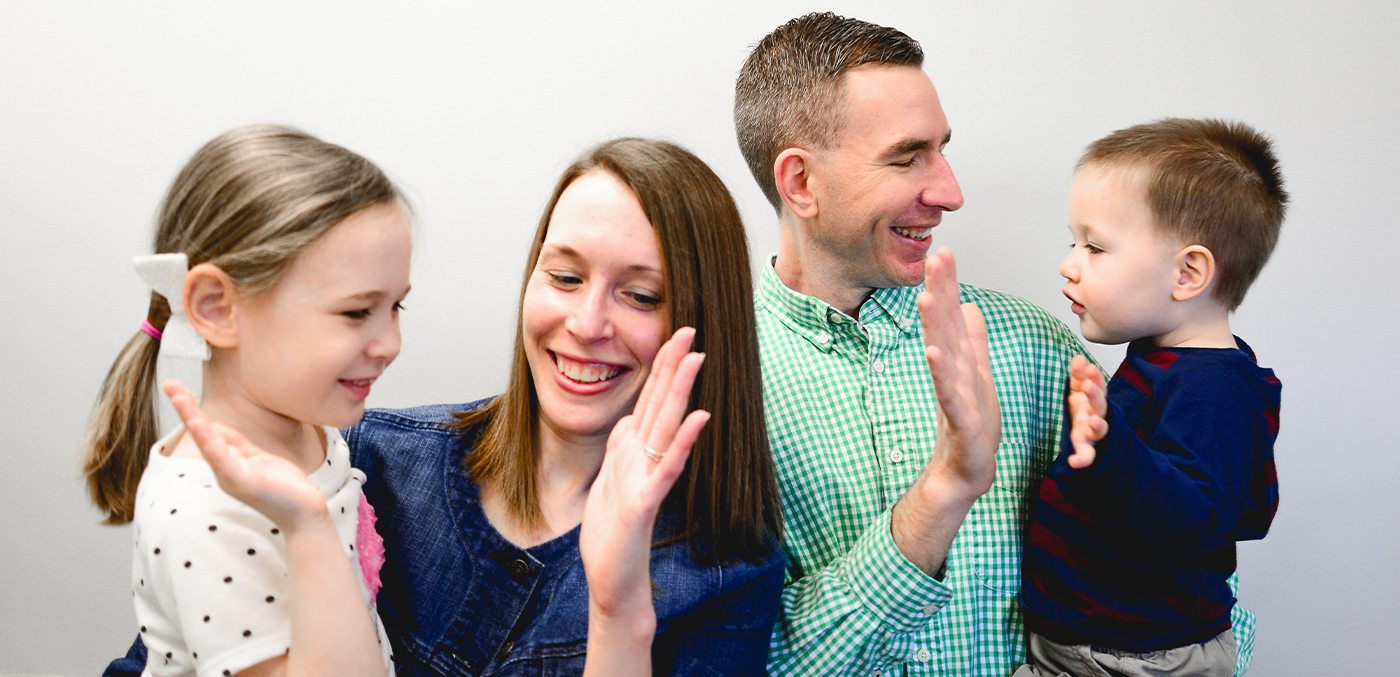 Mother and father each giving one of their children a high five