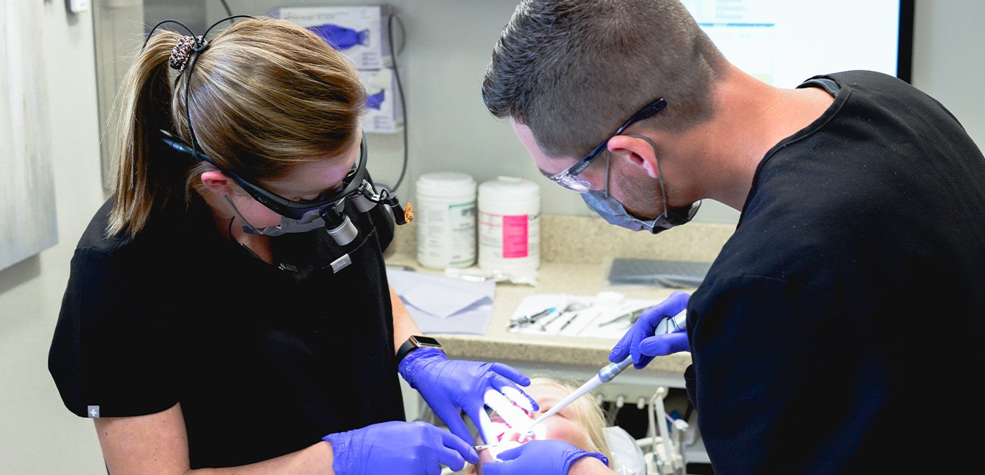 Dentist and dental team member treating a dental patient in Geneva