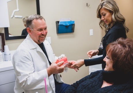 Geneva dentist and dental team member showing a patient dental implant models