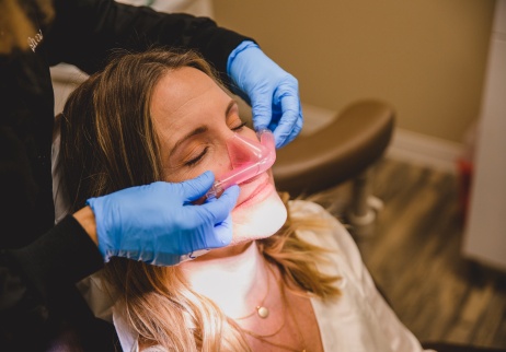 Woman in dental chair with nitrous oxide sedation mask over her nose
