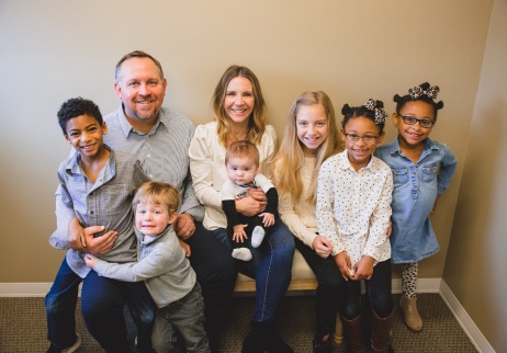 Family with six young kids posing with their dentist in Geneva