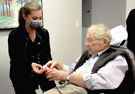 Dental team member in Geneva showing a patient a model of dental implants