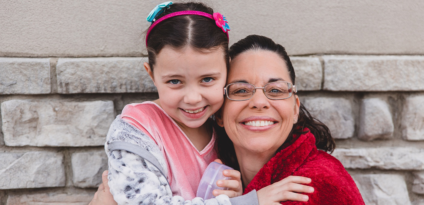 Mother and daughter smiling together at dental office