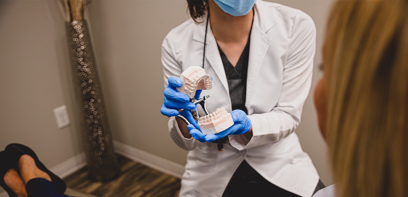 An older woman smiling in a dental office.