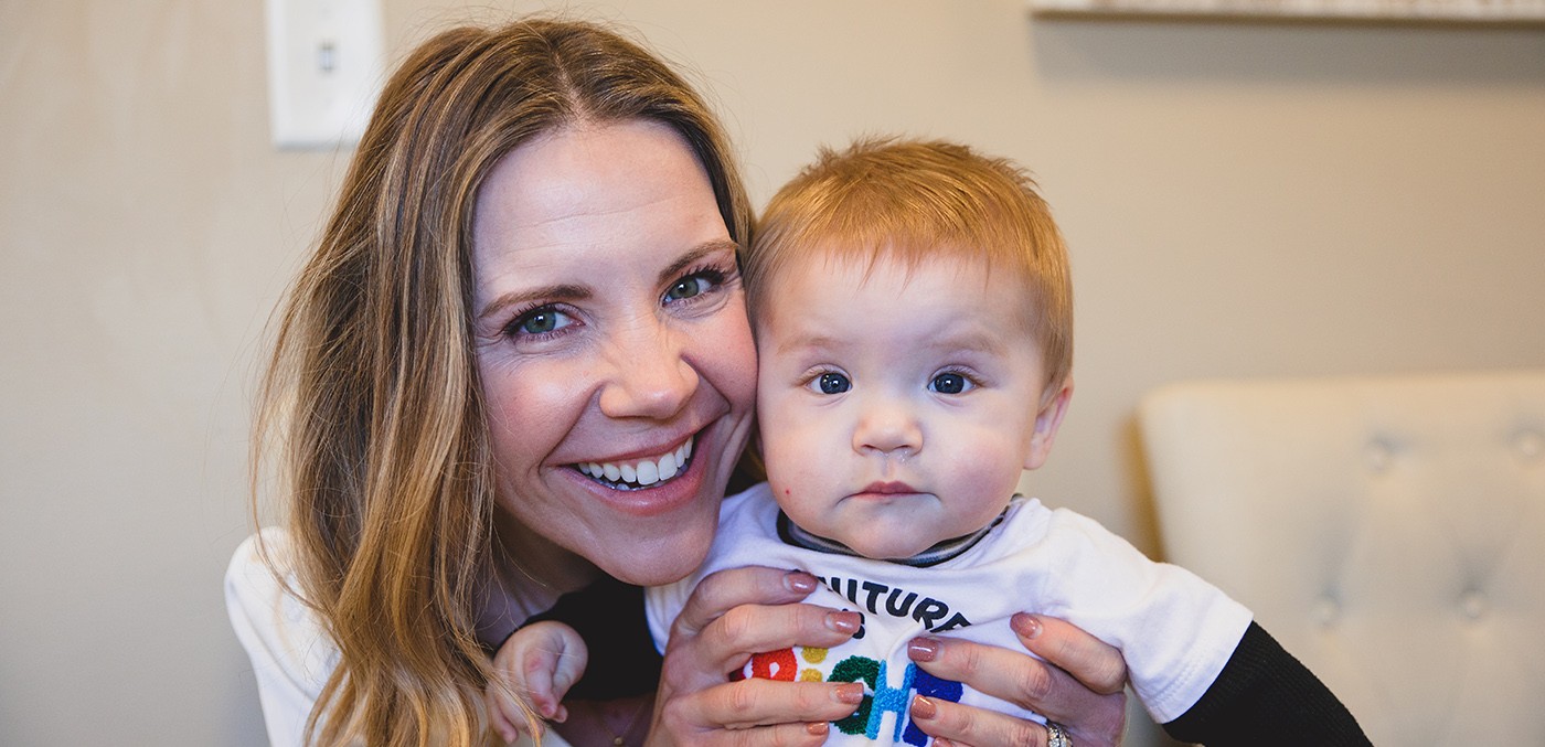 Mother holding infant child and smiling