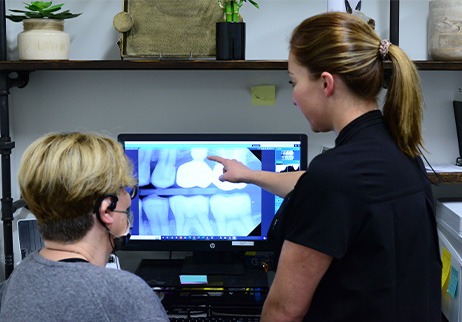 Dentist and dental team member looking at digital x-rays